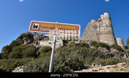 Panneau avec l'inscription 'Château d'Asklipeiou' et ruines d'un ancien château sous un ciel bleu en Grèce, forteresse d'Asklipion, village d'Asklipio Banque D'Images