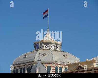 Un bâtiment historique avec un drapeau sur le toit devant un ciel bleu clair, scheveningen, pays-bas Banque D'Images