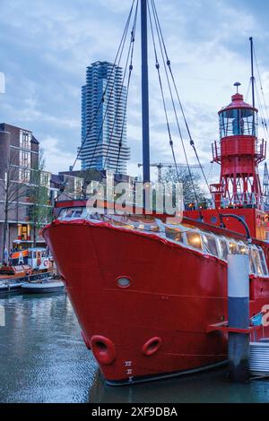 Un phare rouge dans l'eau sous des gratte-ciel modernes dans la ville, rotterdam, pays-bas Banque D'Images