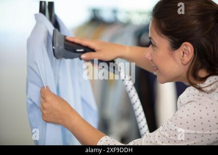 femme fumant chemise chez les nettoyeurs à sec Banque D'Images