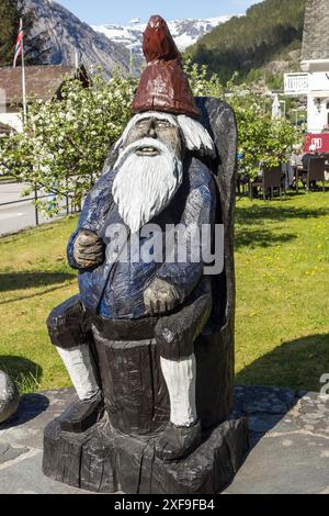 Statue en bois d'un gnome de jardin, assis sur une chaise, sur une place du village par un jour ensoleillé de printemps, Flam, norvège Banque D'Images