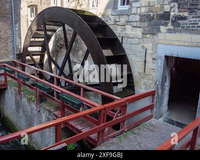 Moulin à eau avec une grande roue de moulin, des garde-corps rouges et un bâtiment historique en briques, maastricht, pays-bas Banque D'Images