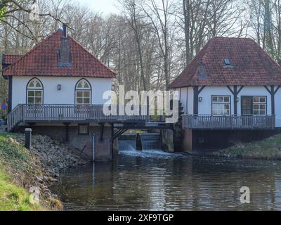 Deux maisons blanches avec des toits de tuiles rouges de chaque côté d'un petit pont sur une rivière, winterswijk, pays-bas Banque D'Images