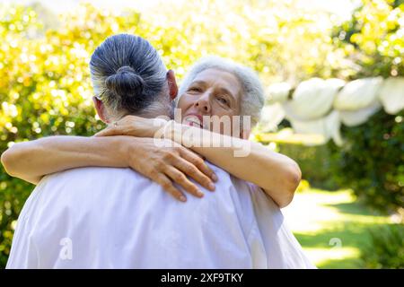 Senior bride hugging groom outdoors, at their wedding Banque D'Images