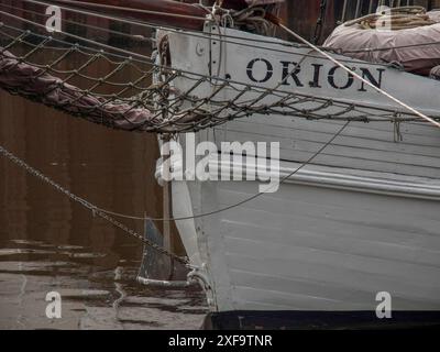 Gros plan de la proue blanche d'un bateau nommé Orion avec des cordes et de l'eau en arrière-plan, carolinensiel, allemagne Banque D'Images