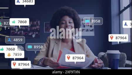 Image des icônes de notification sur la femme d'affaires afro-américaine discutant sur l'appel d'image. Composite numérique, médias sociaux, nombre, croissance, entreprise, Banque D'Images