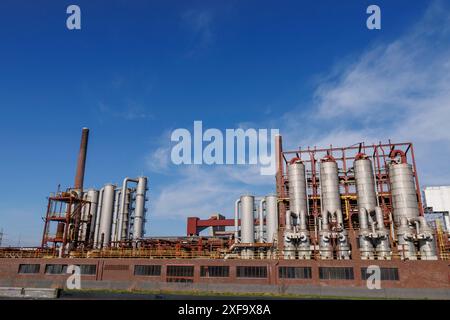 Grande installation industrielle avec de nombreux silos métalliques et cheminées sous un ciel bleu nuageux, essen. région de la ruhr, allemagne Banque D'Images