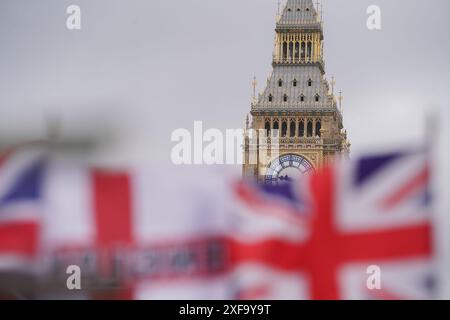 Londres, Royaume-Uni 2 juillet 2024. Les drapeaux de l'Union Jack flottent dans l'enrouleur en face de la tour de l'horloge Big Ben et des chambres du Parlement. Il reste deux jours avant les élections générales du 4 juillet, alors que les électeurs se rendent aux urnes pour élire un nouveau gouvernement. Les sondages prédisent que le leader travailliste Keir Starmer remportera une large majorité. Credit : Amer Ghazzal/Alamy Live News Banque D'Images
