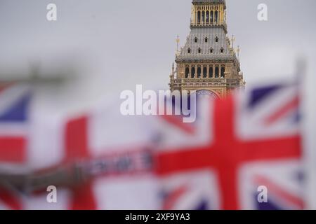Londres, Royaume-Uni 2 juillet 2024. Les drapeaux de l'Union Jack flottent dans l'enrouleur en face de la tour de l'horloge Big Ben et des chambres du Parlement. Il reste deux jours avant les élections générales du 4 juillet, alors que les électeurs se rendent aux urnes pour élire un nouveau gouvernement. Les sondages prédisent que le leader travailliste Keir Starmer remportera une large majorité. Credit : Amer Ghazzal/Alamy Live News Banque D'Images