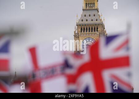 Londres, Royaume-Uni 2 juillet 2024. Les drapeaux de l'Union Jack flottent dans l'enrouleur en face de la tour de l'horloge Big Ben et des chambres du Parlement. Il reste deux jours avant les élections générales du 4 juillet, alors que les électeurs se rendent aux urnes pour élire un nouveau gouvernement. Les sondages prédisent que le leader travailliste Keir Starmer remportera une large majorité. Credit : Amer Ghazzal/Alamy Live News Banque D'Images