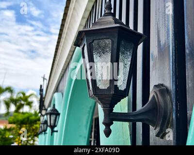 Bâtiment blanc avec fenêtres cintrées, garniture bleue, se dresse haut sous le ciel clair Banque D'Images