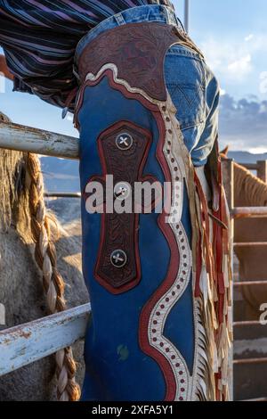 Détail de chapes en cuir frangées sur un cow-boy de rodéo en compétition dans un rodéo dans l'Utah. Banque D'Images