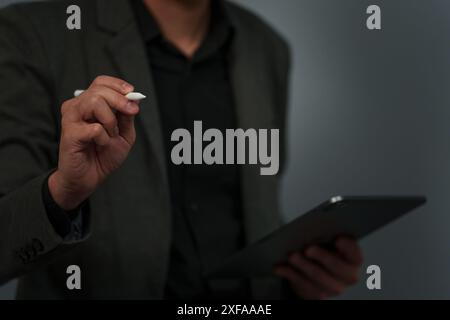 main d'homme d'affaires à l'aide du stylet de stylo écrivant sur l'écran virtuel vide avec tablette numérique Banque D'Images