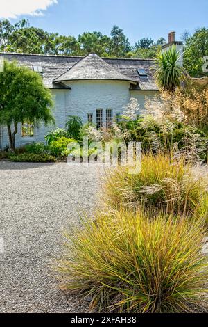 Joli chalet en pierre blanche dans le parc des jardins botaniques Logan sur les Rhinns de Galloway, sud de l'Écosse Banque D'Images