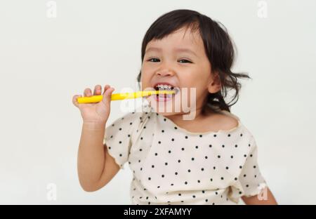 la fillette heureuse se brosse les dents avec le sourire Banque D'Images