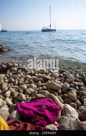 Makarska, Croatie. 1er octobre 2023. Un maillot de bain rose repose sur une plage rocheuse dans une baie. Crédit : Viola Lopes/dpa/Alamy Live News Banque D'Images