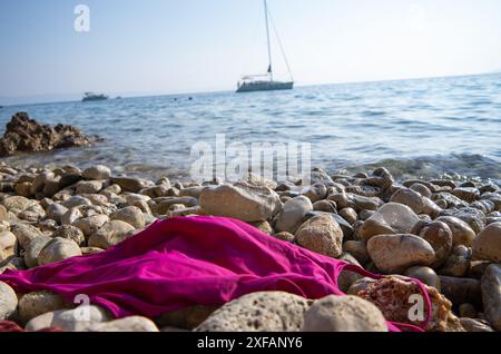 Makarska, Croatie. 1er octobre 2023. Un maillot de bain rose repose sur une plage rocheuse dans une baie. Crédit : Viola Lopes/dpa/Alamy Live News Banque D'Images