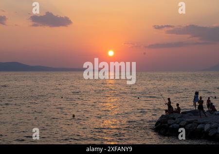 Makarska, Croatie. 1er octobre 2023. Les amateurs de plage se tiennent sur un rocher au coucher du soleil. Crédit : Viola Lopes/dpa/Alamy Live News Banque D'Images