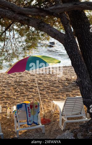 Makarska, Croatie. 1er octobre 2023. Un parasol se tient entre deux chaises longues sur une plage. Crédit : Viola Lopes/dpa/Alamy Live News Banque D'Images