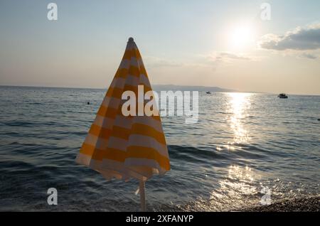 Makarska, Croatie. 1er octobre 2023. Un parasol rayé se dresse sur une plage. Crédit : Viola Lopes/dpa/Alamy Live News Banque D'Images