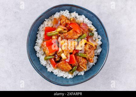 Riz avec des morceaux de porc frit sucré et aigre avec des légumes, vue de dessus Banque D'Images