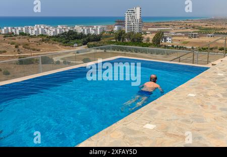 Man relaxing in swimming pool Banque D'Images