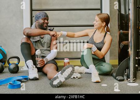 Homme afro-américain et femme caucasienne coup de poing pendant le temps d'étirement Banque D'Images