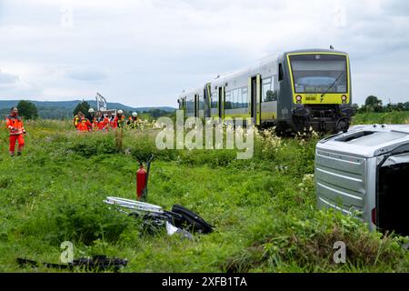 Meeder, Allemagne. 02 juillet 2024. Les services d'urgence sont déployés sur les lieux d'un accident à côté d'une voiture endommagée. Au moins une personne est décédée dans une collision entre un train et une voiture à un passage à niveau dans le district bavarois de Coburg. Credit : Pia Bayer/dpa - ATTENTION : personne(s) a/ont été pixelisée(s) pour des raisons légales/dpa/Alamy Live News Banque D'Images