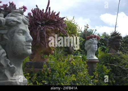 Une rangée de têtes de statues utilisées comme jardinières. Banque D'Images