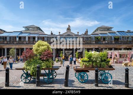 Londres, Royaume-Uni - 9 mai 2024 : les gens apprécient le soleil du début de l'été à Covent Garden Market, Londres. Une attraction touristique populaire et point de repère, avec stree Banque D'Images