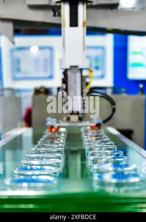 Le fonctionnement de la machine de production automatique de couvercle en verre à boire en plastique pour l'emballage Banque D'Images