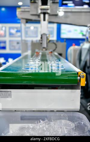 Le fonctionnement de la machine de production automatique de couvercle en verre à boire en plastique pour l'emballage Banque D'Images