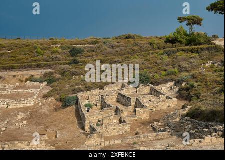 Ruines d'un ancien site sur un terrain vallonné, entouré de végétation et de ciel, maisons hellénistiques, Kamiros, site archéologique, ville antique Banque D'Images