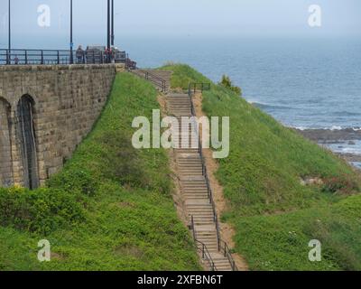 Marches en pierre menant à la côte, flanquée d'une rampe surplombant la mer et le ciel, tynemouth, angleterre, royaume-uni Banque D'Images