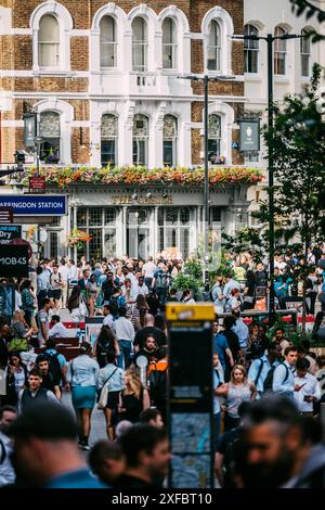 Londres, Royaume-Uni - 27 juin 2024 : scène de rue animée de Londres avec des foules à l'extérieur à Farrington, Londres Banque D'Images