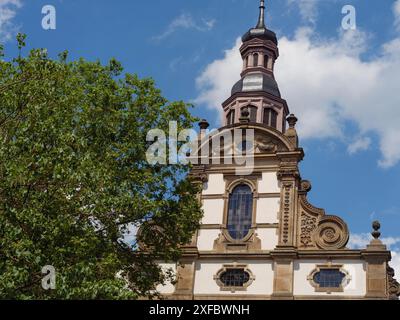 Tour d'église baroque à côté d'un arbre sous un ciel bleu avec des nuages, speyer, allemagne Banque D'Images