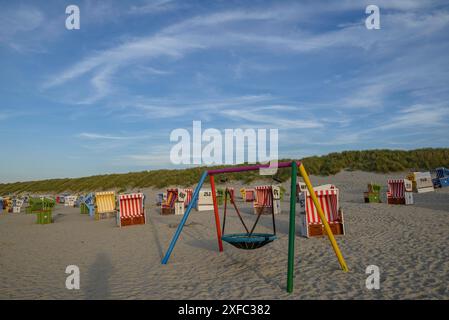 Chaises de plage colorées et balançoire sur la large plage de sable sous un ciel bleu, langeoog, frise orientale, allemagne Banque D'Images