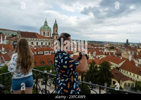 Prague, République tchèque. 01 juillet 2024. Couple de touristes prennent des photos du paysage urbain du centre historique de Prague pendant le temps nuageux. Le centre historique de Prague fait partie des sites du patrimoine mondial de l'Organisation des Nations Unies pour l'éducation, la science et la culture (UNESCO). (Photo de Tomas Tkacik/SOPA images/SIPA USA) crédit : SIPA USA/Alamy Live News Banque D'Images