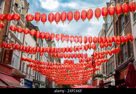 Londres / Royaume-Uni - juin 28 2024 : lanternes chinoises rouges enfilées sur Gerrard St, Chinatown, Londres, Royaume-Uni. Banque D'Images