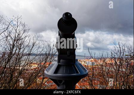 Le télescope surplombe les toits de tuiles d'argile rouge de Lisbonne depuis Castelo de São Jorge, offrant une vue panoramique sur la ville couverte Banque D'Images