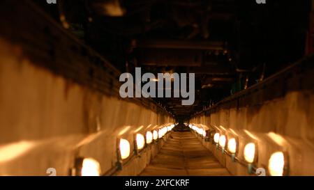 Lanternes illuminées du tunnel. Long abri anti-aérien. Canal de béton. Tranchée pour jeter les communications. Fosse pour câbles. Fosse pour réparer des voitures. Banque D'Images