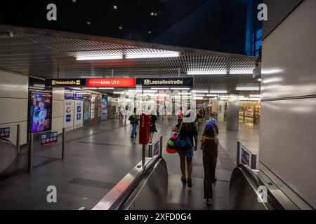 Vienne, Autriche, 18 août 2022. Vie urbaine dans la station de métro : les gens descendent des escaliers mécaniques et marchent dans le grand couloir. Les signes spécifient Hein Banque D'Images