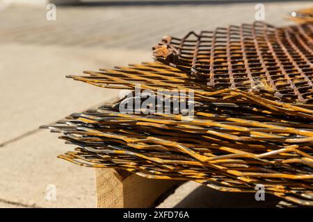 Grilles métalliques rouillées empilées sur une palette en bois - détail en gros plan - texture de la corrosion et des intempéries - ombres projetant la lumière du soleil. Prise à Toronto, CA Banque D'Images