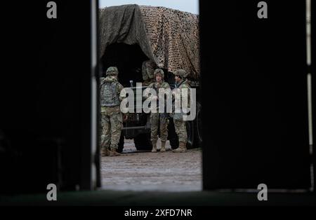 Les soldats de l'armée américaine affectés au quartier général de la 1st Armored Brigade et à la Compagnie du quartier général de la 1st Armored Brigade combat Team, de la 1st Armored Division, tirent la sécurité à l'extérieur de la répétition d'armes combinées (CAR) à la base opérationnelle avancée Seattle au National Training Center, Fort Irwin, Californie, le 5 février 2024. (Photo de l'armée américaine par le SPC David Poleski) Banque D'Images