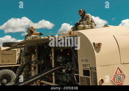 Les spécialistes de l'approvisionnement en pétrole de l'armée américaine avec le 1er Bataillon, le 168e Bataillon d'aviation de soutien général, le 96e Aviation Troop Command, la Garde nationale de Washington, ravitaillent un hélicoptère UH-60 Black Hawk au point d'armement et de ravitaillement avant (FARP) pendant la formation annuelle au centre de formation de Yakima, Washington, le 16 juin 2024. Le FARP ressemble à une station-service complète pour hélicoptères militaires où le personnel au sol peut ravitailler un avion en quelques minutes, sans avoir à arrêter le moteur. (Photo de la Garde nationale de l'armée américaine par le sergent d'état-major Adeline Witherspoon) Banque D'Images