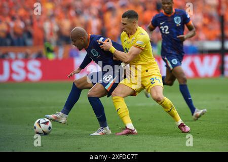 Munich, Allemagne. 2 juillet 2024. Donyell Malen (G), des pays-Bas, affronte Bogdan Racovitan, de Roumanie, lors du match de l'UEFA Euro 2024 Round of 16 opposant la Roumanie et les pays-Bas à Munich, Allemagne, le 2 juillet 2024. Crédit : Meng Dingbo/Xinhua/Alamy Live News Banque D'Images