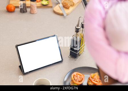 Cuisiner dans la cuisine, homme utilisant la tablette pour la recette tout en préparant le repas, copier l'espace Banque D'Images