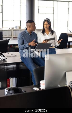 Collaboration au bureau, collègues discutant du projet à l'aide d'un ordinateur portable et d'une tablette Banque D'Images