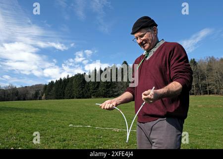 France, territoire de Belfort, Rougegoutte, Meadow, Denis Boyer, dowser, recherche de l'eau souterraine, divining des tiges Banque D'Images
