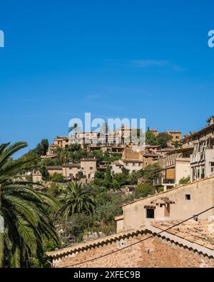 Superbe paysage urbain du petit village côtier de Deia à Majorque, Espagne. Maisons traditionnelles mitoyennes sur des collines entourées d'arbres verdoyants. Touriste de Banque D'Images